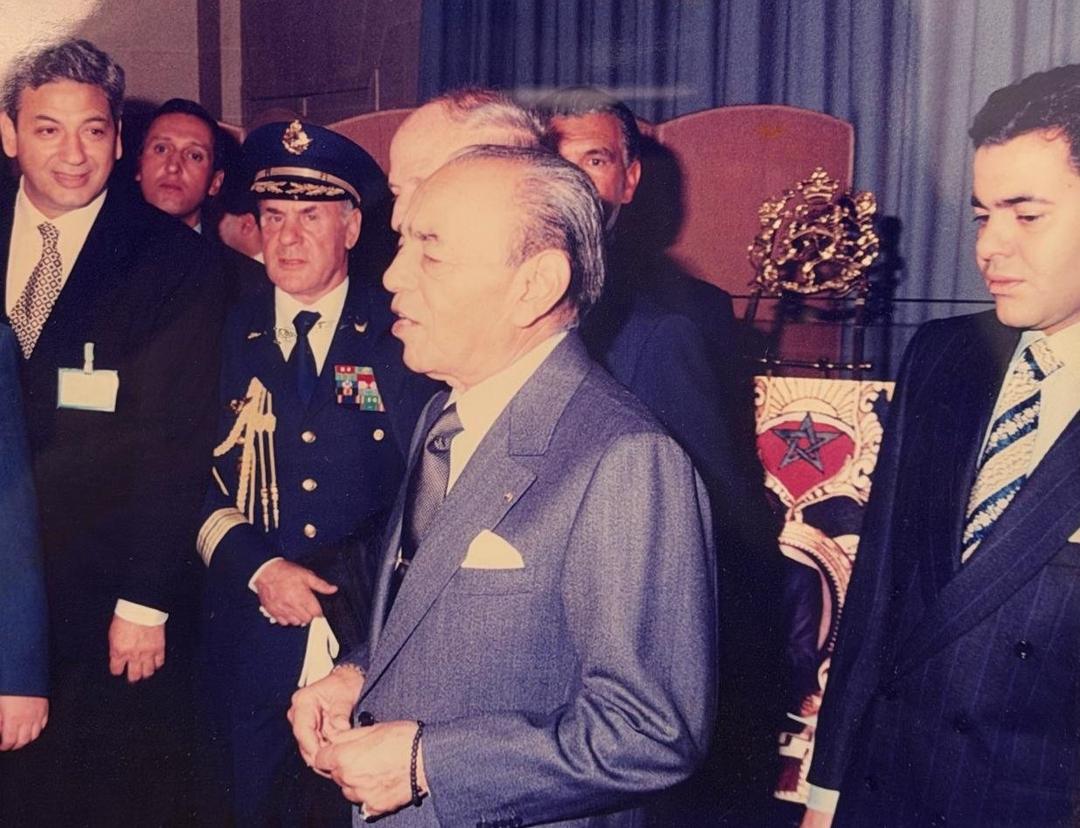 Marcel Cohen, on the left, at a reception held by King Hassan II of Morocco; the royal emblem stands on the chair behind the king
