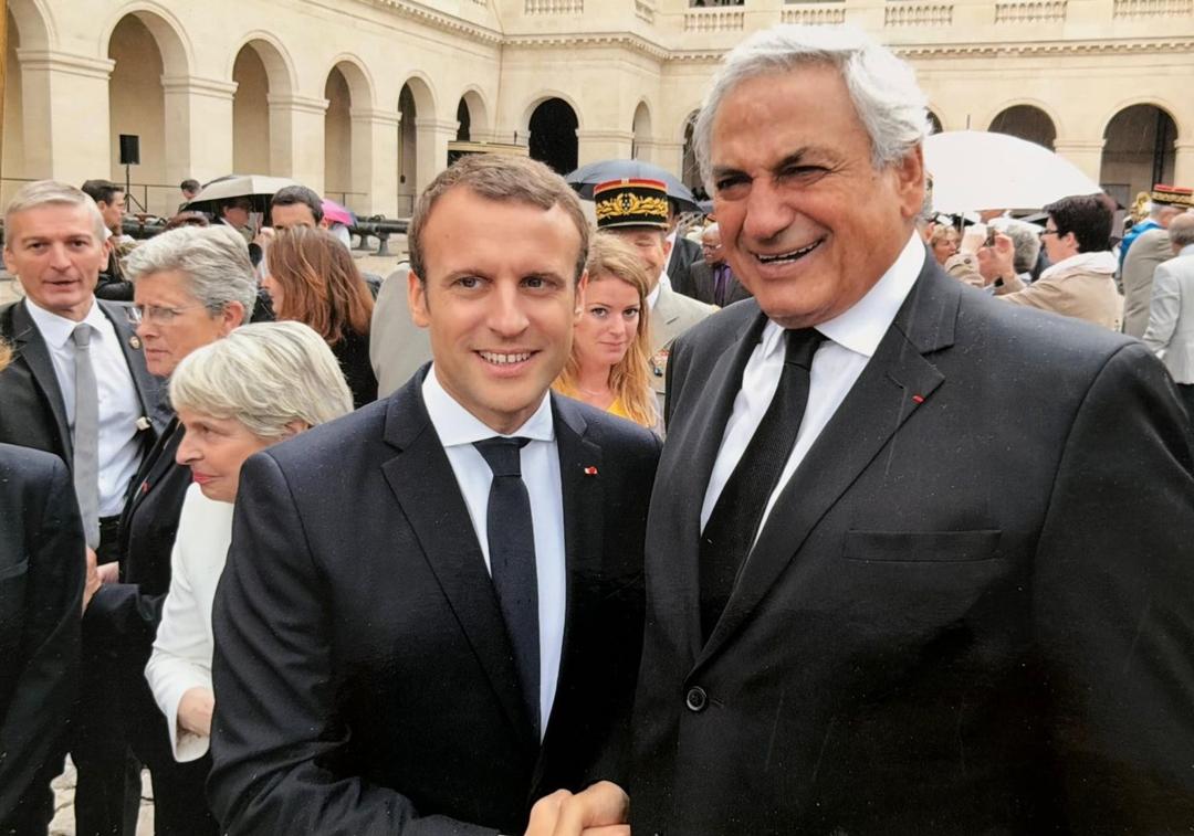 Marcel Cohen with Emmanuel Macron, President of the Republic, in the rain in the cour d'honneur of the Invalides; the red ribbon of the Légion d'Honneur is at his lapel